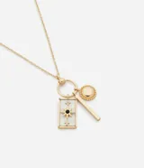 Collar dorado con cadena fina y dijes colgantes: rectángulo de nácar con estrella negra y strass, círculo con textura y barra lisa.