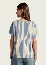Blusa de manga corta con estampado a cuadros claros sobre fondo marrón, cuello redondo y corte holgado.