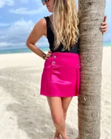 Minifalda fucsia de corte recto con botones decorativos en la parte delantera.