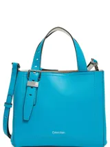 Cartera tipo tote de tamaño compacto en color azul vibrante, confeccionada en piel sintética lisa. Presenta doble asa de mano, correa ajustable para llevar al hombro o cruzada, y detalle de hebilla decorativa con logo grabado en el frente.