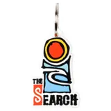 Llavero de goma blanco con diseño gráfico de un círculo rojo con borde amarillo, una forma abstracta celeste y la frase "The Search" en naranja.
