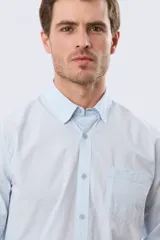 Camisa lisa de manga larga de algodón en color gris claro, de corte slim fit con cuello camisero y cierre frontal de botones.