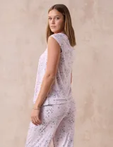 Conjunto de pijama marca René Rofé, compuesto por remera de mangas cortas con escote en V abotonado y pantalón capri con cintura elastizada. Diseño estampado con flores azules sobre fondo blanco.