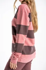 Sweater tipo polo de manga larga con diseño de rayas horizontales en tonos rosa y gris oscuro. Presenta cuello clásico y puños acanalados, confeccionado en algodón peinado.