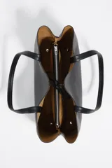 Bolso shopper de piel color borgoña, con textura granulada, asas de hombro y cierre de cordón. Presenta el logo metálico de Bimba y Lola en el frente.