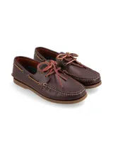 Mocasines tipo náutico color marrón oscuro, confeccionados en cuero, con cordones de cuero en contraste y suela de goma plana.