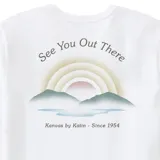 Remera blanca de algodón con cuello redondo y mangas cortas. Estampado pequeño en el pecho con un arcoíris y el texto "Kanvas by Katin".