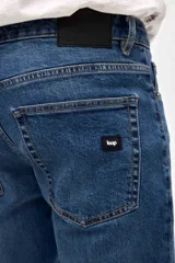 Jean de corte slim, con ajuste en cadera y muslos, y pierna levemente entallada desde la rodilla hasta el tobillo. Presenta un lavado azul medio clásico con costuras reforzadas.