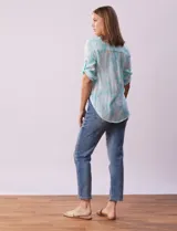 Blusa celeste con estampado blanco, de gasa, con cuello a la base y escote en V. Tiene abertura con botones, bolsillos delanteros y mangas 3/4 regulables con presilla y botón. El ruedo termina con un nudo.