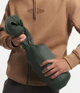 Campera puffer ultraligera de color beige, con diseño acolchado de gajos horizontales, capucha incorporada, cierre frontal y bolsillos laterales con cremallera. Confeccionada en poliamida con relleno de poliéster.