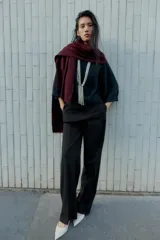 Bufanda de punto fino en color beige, con diseño liso y terminaciones tejidas.