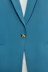 Blazer negro de cuello con solapas de muesca y hombreras, con mangas tres cuartos drapeadas, bolsillos de vivo simulados y cierre frontal con un botón dorado. Forro interior a tono.