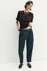 Pantalón chino de tiro medio confeccionado en denim oscuro. Presenta pinzas en el delantero, bolsillos laterales y bajo con acabado en vuelta. Cierre frontal con cremallera y botón.