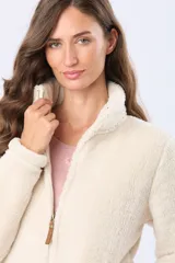 Campera de sherpa color crema con cuello alto y cierre frontal con tirador de cuero. Presenta un diseño de textura suave y abrigada.