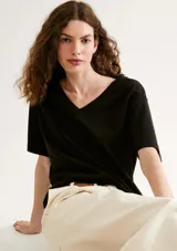 Blusa negra de manga corta con escote en V pronunciado y calce holgado (oversized).