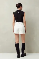 Short de algodón de tiro alto, color beige, con bolsillos delanteros tipo parche con solapa y botones a la vista.