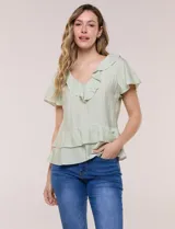 Blusa de satén texturizado color verde menta, con escote en V y volados que bordean el cuello. Presenta mangas cortas acampanadas y doble nivel de volados en la parte inferior, formando una silueta péplum.
