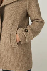 Chaquetón de lana fina sin teñir, con cuello clásico, cierre frontal de botones, bolsillos ojal y detalle de martingala en los puños. Incluye forro interior al tono.