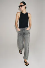 Jeans de tiro medio con corte relajado y largo al tobillo. Presenta diseño de cinco bolsillos, trabillas en la cintura y cierre frontal con cremallera y botón metálico.