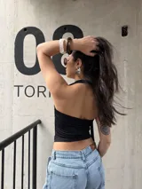 Top negro de jersey lycra, con escote redondo y detalle de tiras colgantes en el hombro.