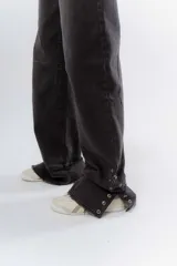 Pantalón de jean negro de corte recto y tiro alto, con detalle de botones en el dobladillo de la pierna.