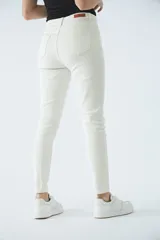 Jean de tiro alto color azul, corte skinny, con cierre de cremallera y bolsillos.