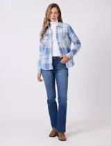 Sobrecamisa de tejido soft con estampado de cuadros en tonos azules y blancos. Presenta cuello con solapa, cierre frontal con botones, bolsillos aplicados en el pecho y mangas largas con puños abotonados. El interior cuenta con un acabado afelpado.