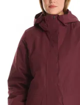 Campera 3 en 1 de color beige, con sistema de capas desmontables. La capa exterior es de tejido técnico resistente al viento y lluvia ligera, con capucha fija, cierre frontal con solapa, bolsillos de parche y ajuste elástico interno en la cintura. Incluye una campera interior capitoneada ultraliviana que puede usarse de forma independiente.