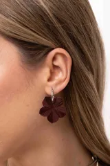 Aros colgantes con argolla de acero quirúrgico y dije en forma de flor pintado a mano con acabado nacarado.