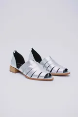 Sandalias de cuero negro con talón descubierto, tiras anchas entrecruzadas en el empeine y taco bajo de madera.