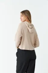 Remera de manga larga color beige, con capucha ajustable y puños. Tejido de punto acanalado.