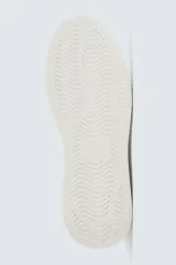 Zapatillas deportivas blancas con detalle de color gris en el talón y suela con volumen.