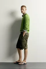Sweater de punto canalé en hilatura de algodón, color verde, con cuello en V y manga larga.
