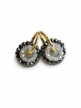 Dijes colgantes circulares para aros, elaborados con piedras de cristal facetadas en tonos grises y transparentes encapsuladas en resina, con argolla dorada superior.