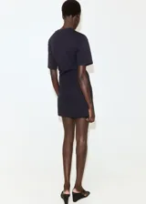 Vestido corto negro de manga corta y cuello redondo, con detalle de lazo cruzado en la cintura.
