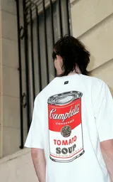 Remera blanca de manga corta, con cuello redondo y calce regular. En la espalda presenta un gran estampado inspirado en la icónica lata de sopa Campbell's de Andy Warhol.