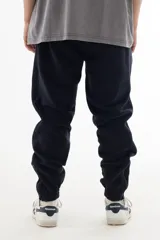 Pantalón de jogging azul marino de algodón grueso con interior cálido, corte amplio, tiro medio, cintura elástica con cordón, cierres en los tobillos y logo "vernal" bordado en la pierna izquierda.