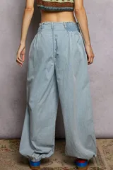 Pantalón ancho de jean claro, confeccionado en algodón, con cintura fruncida y puños elásticos.