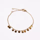 Pulsera dorada de cadena fina con cierre de mosquetón y cadena de alargue. Presenta dijes colgantes en forma de pequeñas monedas.