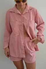 Camisa a rayas rojas y blancas de manga larga, con cuello clásico y corte holgado.
