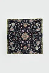 Pañuelo cuadrado de tela fina color negro con estampado floral en tonos pastel y borde verde.