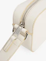 Cartera cruzada rectangular de color blanco roto, con ribetes y detalles en color beige claro. Presenta un parche rectangular con la insignia de Tommy Jeans en la parte frontal inferior derecha.