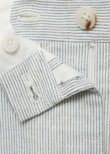 Pantalón de tiro medio con diseño recto y estilo sastrero. Confeccionado en tejido mezcla de algodón y lino con estampado de rayas verticales finas. Cuenta con cierre delantero de cremallera y botón, trabillas para cinturón y bolsillos laterales.