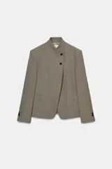 Blazer de cuello subido con cierre frontal cruzado de botones. Presenta manga larga con hombreras y puños con botones, bolsillos de vivo en el delantero y forro interior.