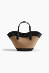Bolso tipo canasta con cuerpo de tela color camel y detalles, asas y bandolera de cuero sintético negro. Presenta costuras blancas contrastantes en todos los bordes. Incluye asas de mano y una correa ajustable y desmontable para llevar al hombro o cruzado.