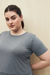 Remera deportiva color lila de manga corta con calce relajado y corte horizontal en la parte inferior.