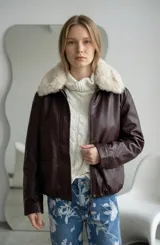 Campera de ecocuero color bordó con cierre frontal, puños y ruedo elásticos. Presenta un cuello de piel sintética desmontable en color crema.