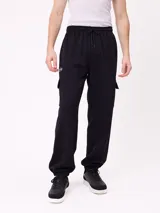 Babucha de estilo cargo en color negro, confeccionada en tejido de algodón y poliéster. Presenta cintura elástica con cordón ajustable, bolsillos laterales tipo cargo y puños elásticos en los tobillos.