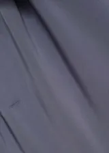 Mono largo de diseño asimétrico en color azul grisáceo, confeccionado en tejido fluido con acabado satinado. Presenta un solo tirante ancho con detalle de nudo y cierre lateral oculto.