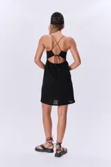 Vestido corto negro con breteles finos y escote recto con frunce.